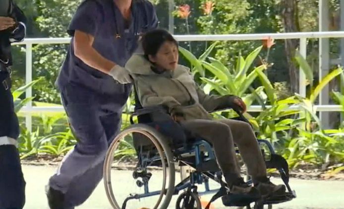 De Zuid-Koreaanse Joohee Han wordt in een rolstoel het ziekenhuis ingebracht.