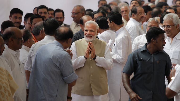 De Indiase eerste minister (midden) en andere parlementsleden staan in de rij om hun stem uit te brengen. Beeld ap