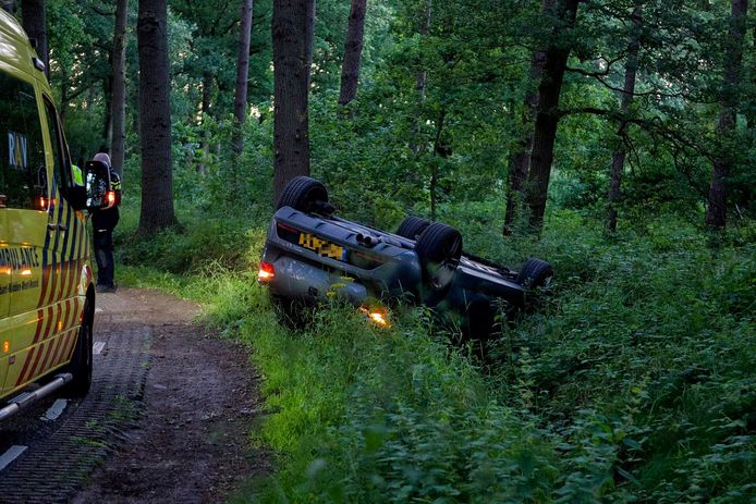 De auto belandde op de kop naast de weg in Halsteren.