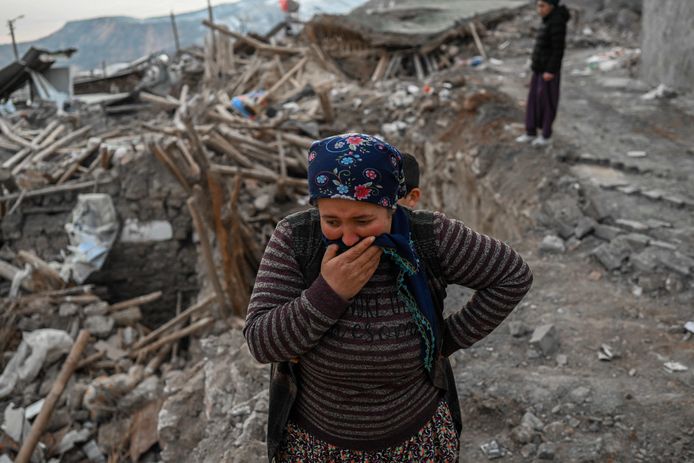 Een vrouw huilt terwijl ze op het puin staat van een ingestort huis in het dorp Yaylakonak, waar 108 mensen omkwamen en 170 huizen instortten na de aardbeving.