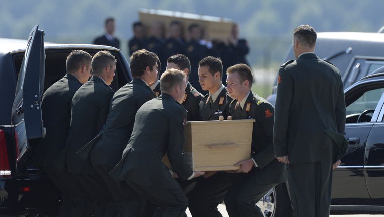 Militairen op vliegbasis Eindhoven dragen een kist met daarin een van de slachtoffers van de vliegramp in Oekraïne. Beeld anp