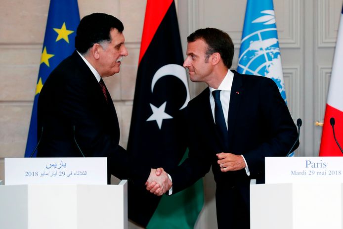 De Libische premier Fayez al-Sarraj en de Franse president Emmanuel Macron schudden elkaar de hand.