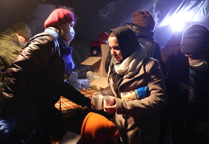 Migranten krijgen een warme maaltijd in een opvangcentrum aan de Pools-Wit-Russische grens.