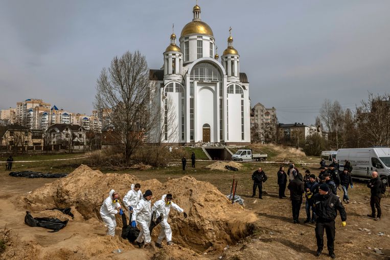 April 2022: Investigators retrieve bodies from a mass grave in Bocha.  Image NYT