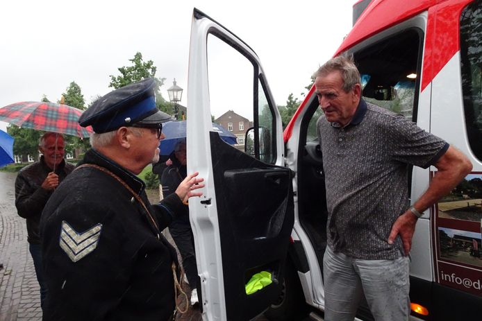 Verkleed als agent houdt collega Leo Huijbers oprichter Jac de Graaf van de buurtbus staande. ,,U mag niet meer rijden.''