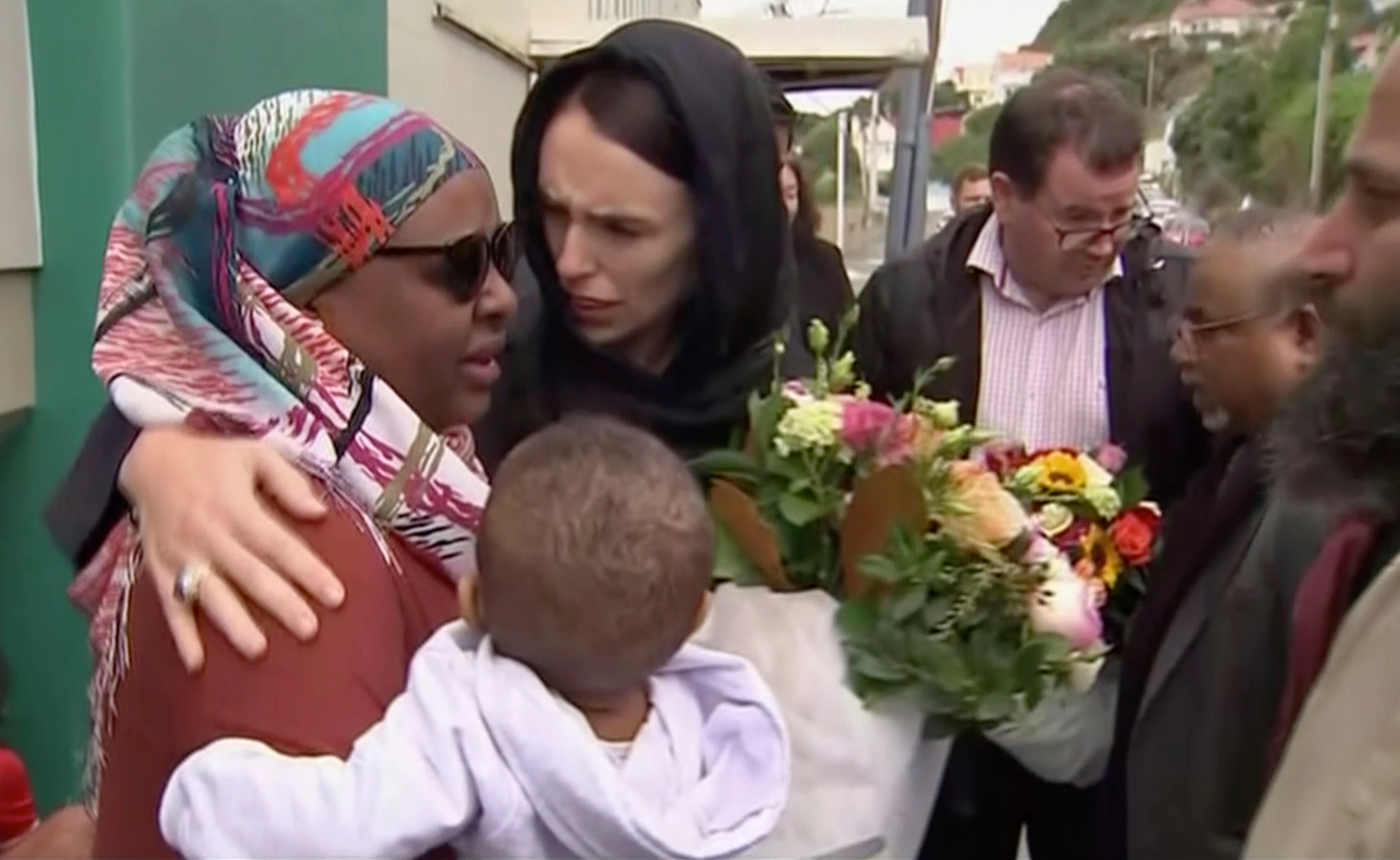 De Nieuw-Zeelandse premier Jacinda Ardern troost een vrouw bij een bezoek aan de Kilbirnie moskee in Wellington, waar bloemen worden neergelegd voor de slachtoffers van de aanslag in Christchurch.