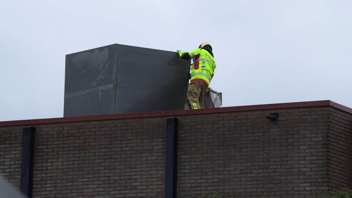 De brandweer demonteert eengevaarlijk object op het dak van Friesland Campina in Varsseveld.