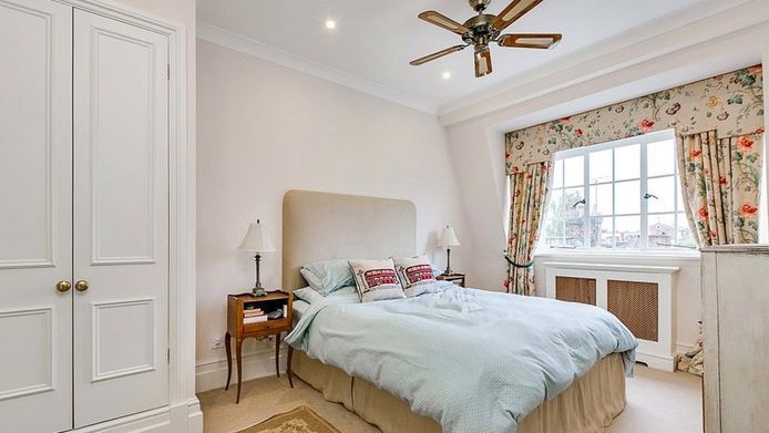 Ook de slaapkamer heeft neutrale kleuren en klassieke meubels, al vormen de ‘Londen’-kussens een leuk accent.