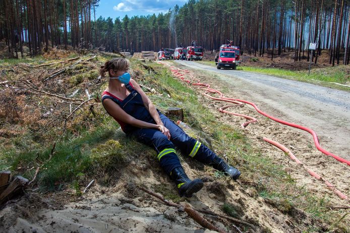 Een vermoeide brandweervrouw neemt rust na het blussen van de enorme bosbrand in Mecklenburg-Vorpommern.