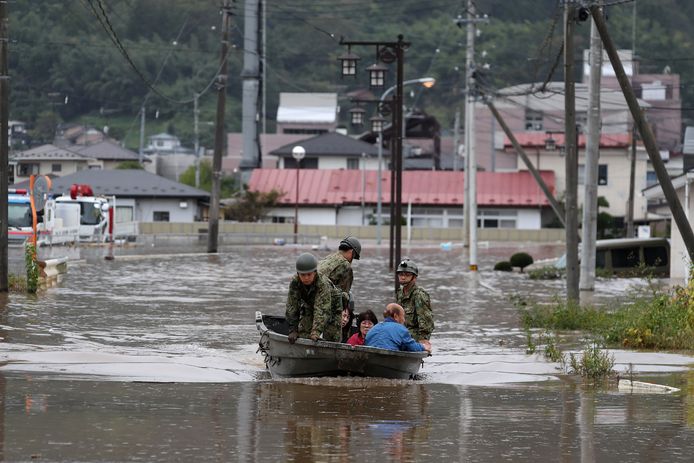 Reddingswerkers halen bewoners uit hun overstroomde huizen.