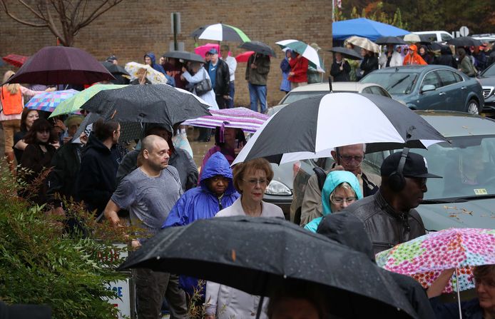 Stemmers in Richmond, Virginia staan in de stromende regen in de rij te wachten