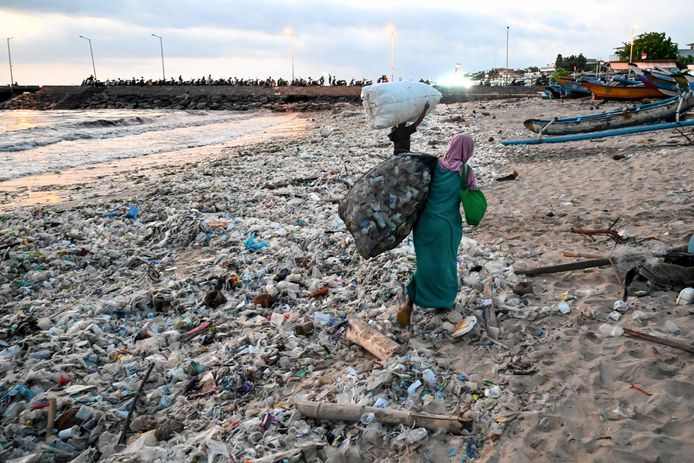 Une femme transporte des sacs de déchets recyclables pour les vendre à Bali, Indonésie, le 19 mars 2024.