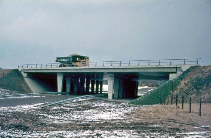 Een grote zandauto rijdt over een viaduct bij Apeldoorn, tijdens de aanleg van de A1, een halve eeuw geleden.