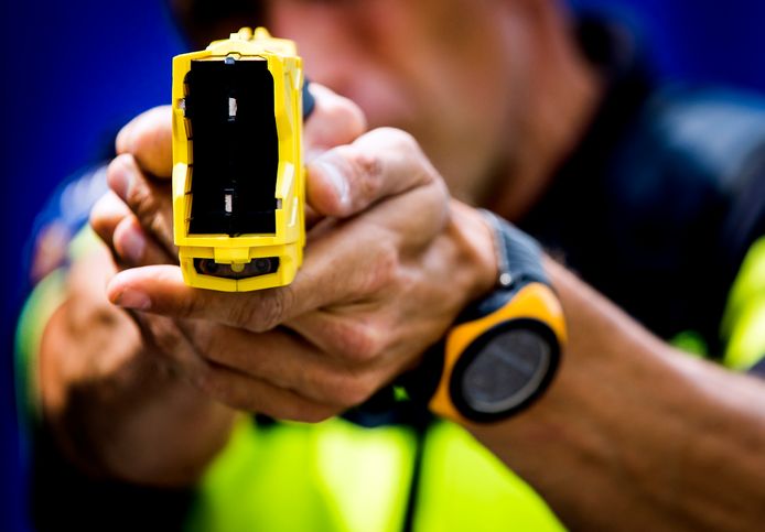 Een politieman hanteert het stroomstootwapen, ook wel taser genoemd.
