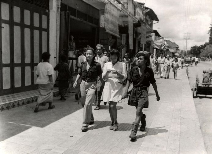 Three young Indonesian women on the street, including two Republican members of the armed youth organization KRIS (Jogjakarta, 1947).