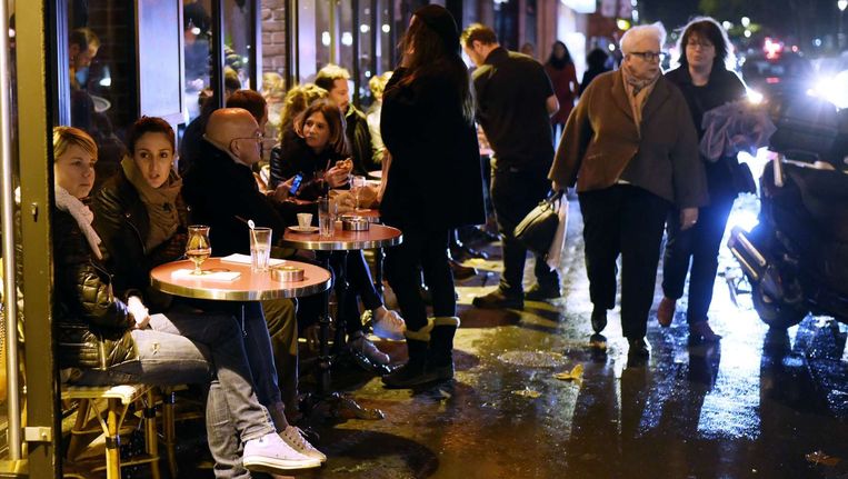 Mensen drinken wat op het terras van een bar in het 11e arrondissement in Parijs. Beeld anp