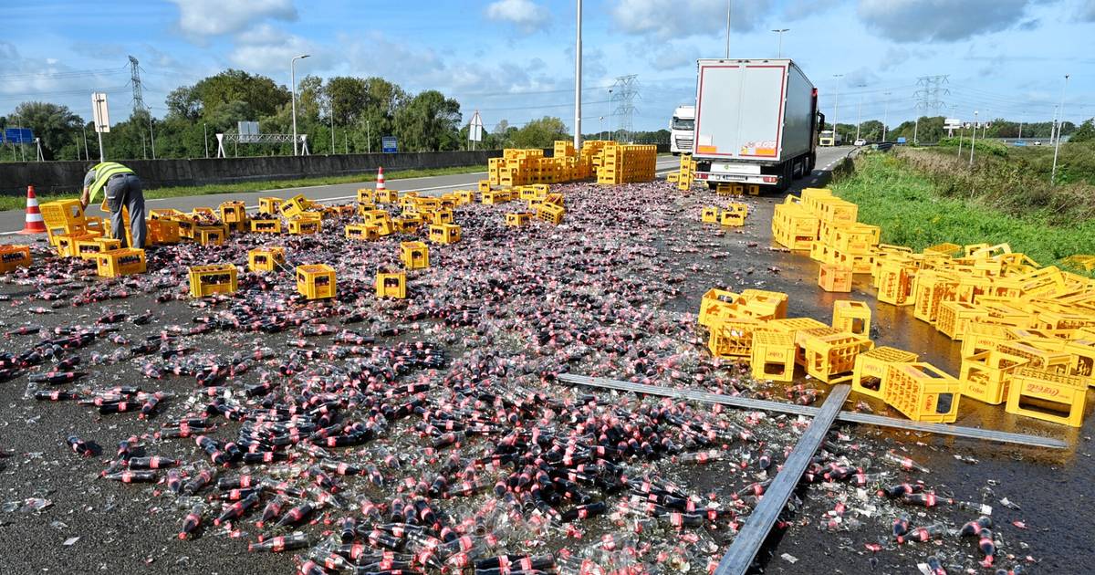 Volledige trucklading flessen Coca-Cola afgeschreven na ongeluk, snelweg vol plakkende glasscherven.