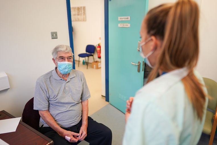 Een oudere patiënt krijgt nog wat uitleg van een arts voor hij een coronavaccin krijgt in het Verenigd Koninkrijk. Beeld Getty Images