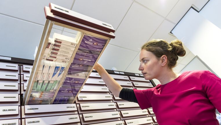 Een apothekersassistente zoekt medicijnen bij elkaar. Beeld anp