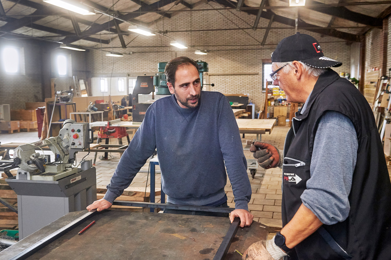 Initiatiefnemer Rick de Voogt van RAUW Collectief voert met vrijwilliger Rene werkoverleg in de werkplaats in de voormalige fietsenstalling aan de Osse Spoorlaan.