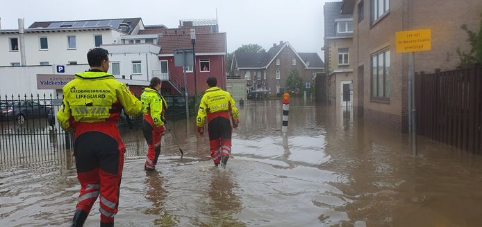 Foto van de overstromingen in Limburg vorig jaar. Hulpdiensten zoeken naar mensen in nood.