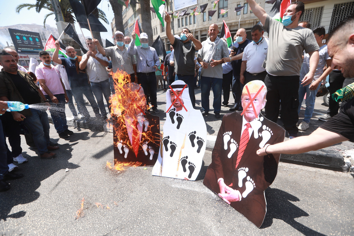 Palestijnen verbranden afbeeldigen van de Israëlische premier Netanyahu, kroonprins van Abu Dhabi Mohammed bin Zayed en de Amerikaanse president Trump. Beeld EPA