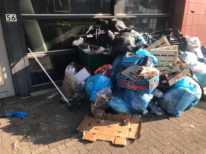 Het gekraakte pand ligt vol vuilnis.