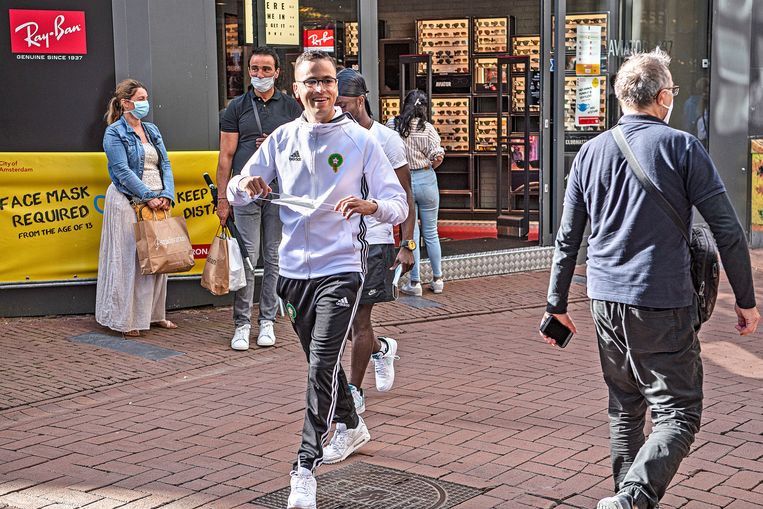 Veruit de meeste mensen zetten braaf hun mondkapje op bij het betreden van de straat, maar een paar honderd meter verderop hangt het in veel gevallen alweer op de kin Beeld Guus Dubbelman / de Volkskrant