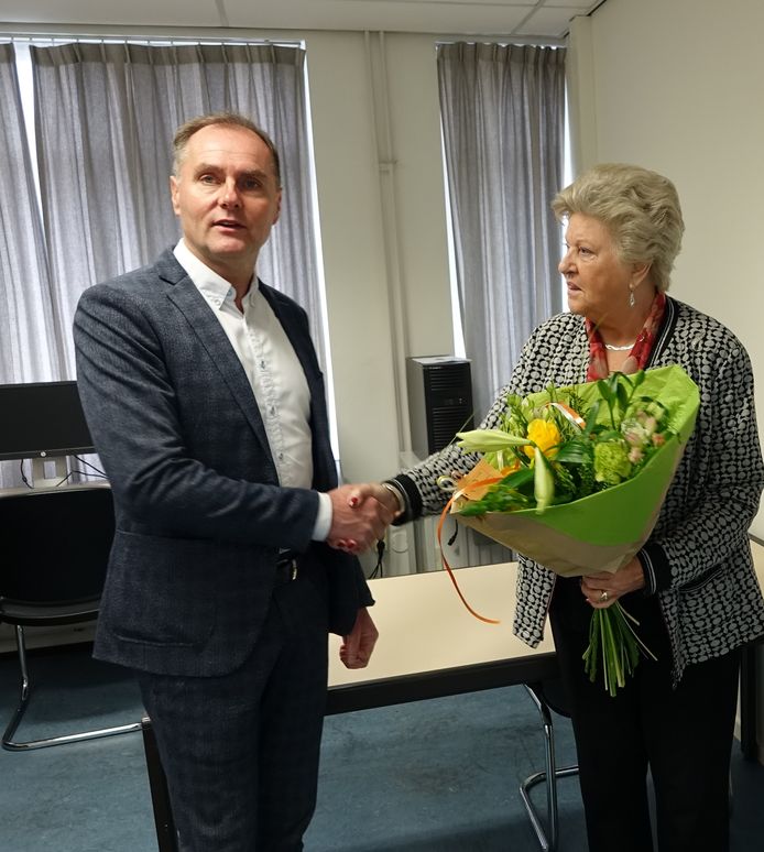 Voorzitter Wil van der Heijden van SO&I overhandigt een boeket bloemen aan de 4000e cursist mevrouw Emmy Brandsma (83) uit Bergeijk