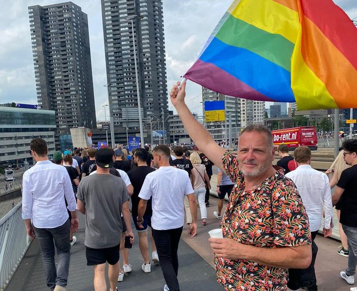 Jan laat zijn regenboogvlag zien tijdens de protestmars.