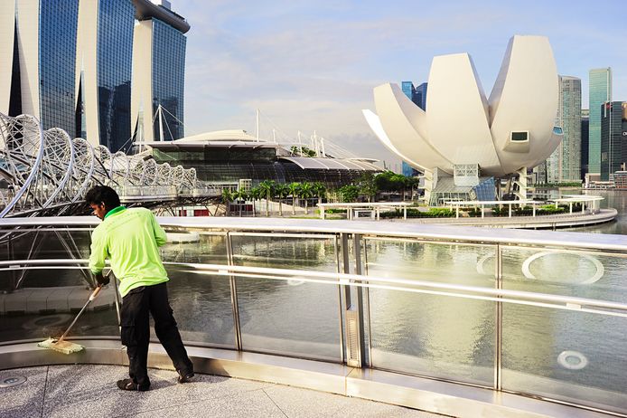 Foto ter illustratie. Een schoonmaker in aan het werk in Singapore