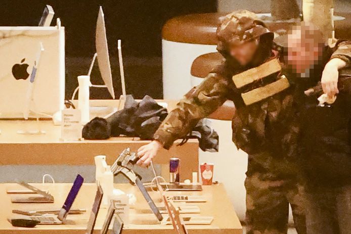 De gijzelnemer Abdel Rahman A. heeft zijn arm over een schouder van de gegijzelde geslagen, tijdens de overval in de Apple Store op het Leidseplein.