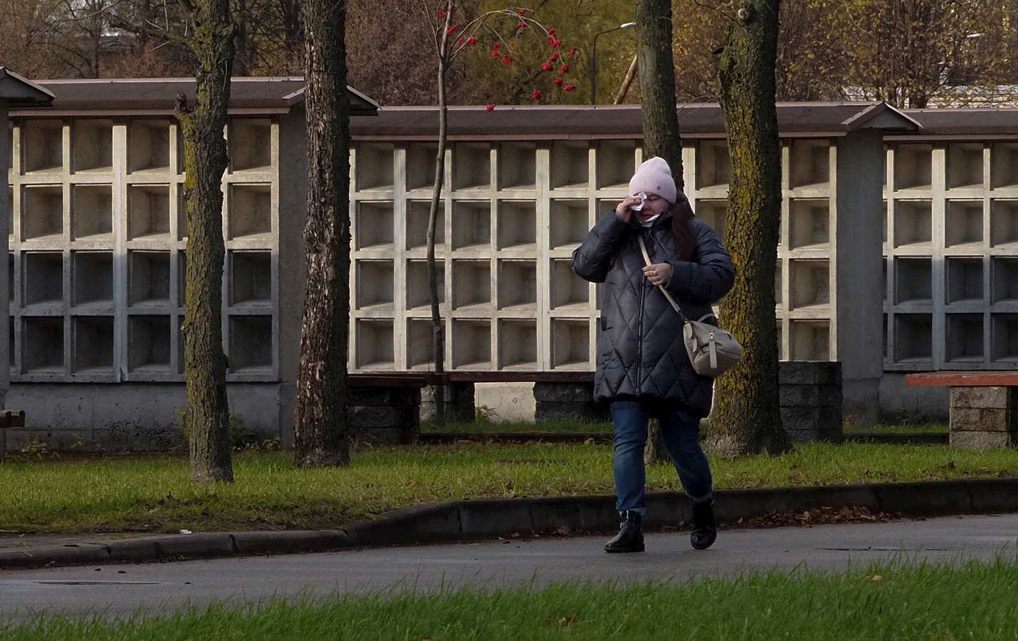 Een vrouw veegt tranen weg wanneer ze langs een leeg columbarium loopt in Sint-Petersburg.