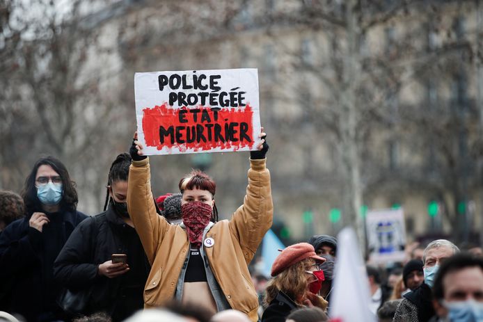 A person holds a placard reading ''protected police, murderous state'' during demonstration against the "Global Security Bill'', that right groups say would make it a crime to circulate an image of a police officer's face and would infringe journalists' freedom in the country, in Paris, France, January 30, 2021. REUTERS/Benoit Tessier