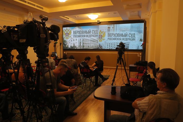 Journalisten volgen de uitspraak van het Russische Hooggerechtshof op een videoscherm in Moskou.