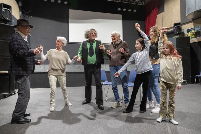 De spelersgroep repeteert een scene, de leeftijd van de acteurs varieert van 10 tot 87 jaar oud.