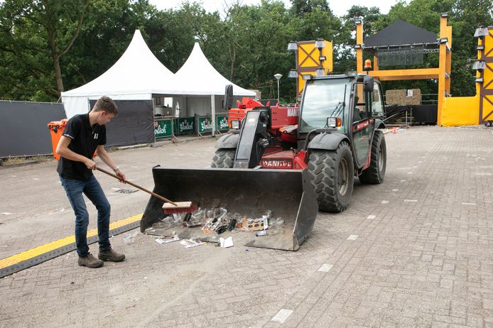 Een van de vrijwilligers ruimt zaterdag de boel op op het festivalterrein bij de Spartelvijver in Sibculo. Het Allermooiste Feestje mocht slechts een avond knallen