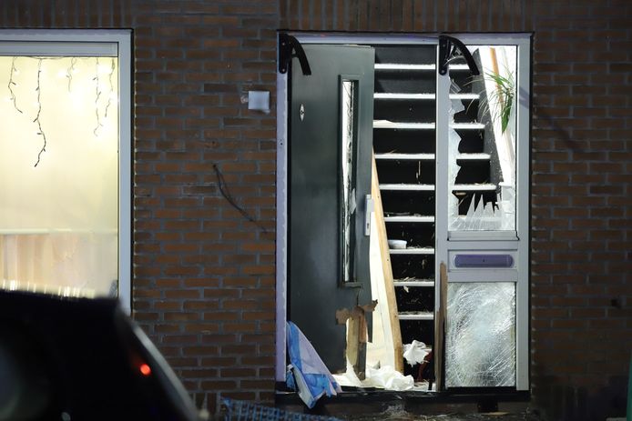 De deur en de ruiten van de woning zijn flink toegetakeld na de explosie.