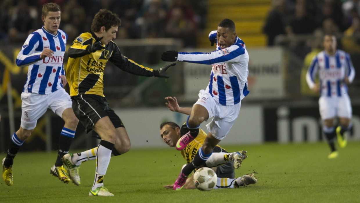 Rajiv van la Parra in duel met Eric Bothegin van NAC. Links kijkt man van de wedstrijd Alfred Finnbogason toe. Beeld PROSHOTS
