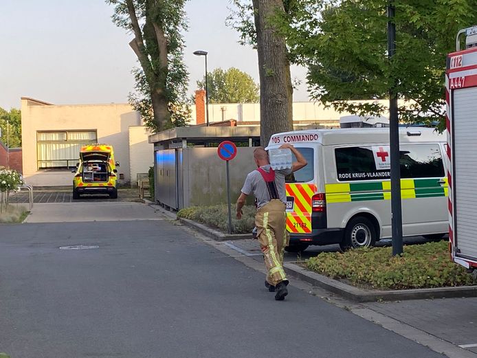 Een brandweerman draagt waterflesjes naar de lokalen om aan de kinderen te geven.