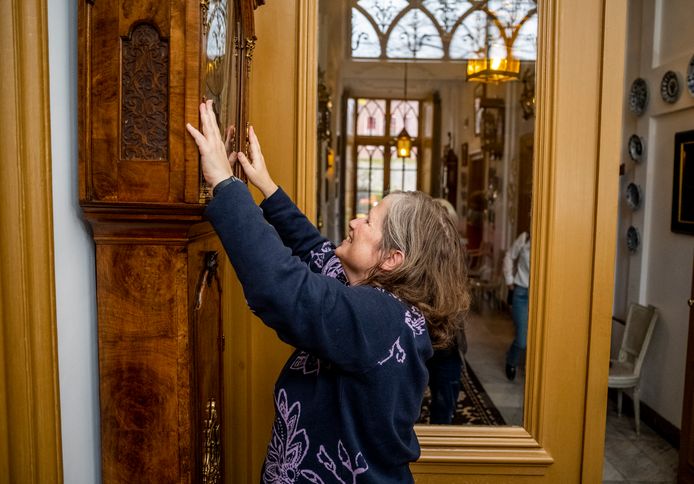 Marianne Lenten voelt aan de bijzondere staande klok in de hal van Huis Van Gijn.