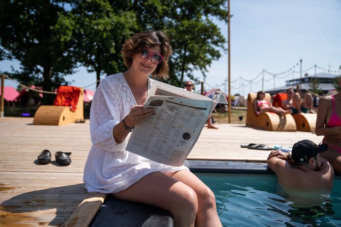 De luxecamping op Tomorrowland. Felice leest er de krant, mét de voetjes in het water.