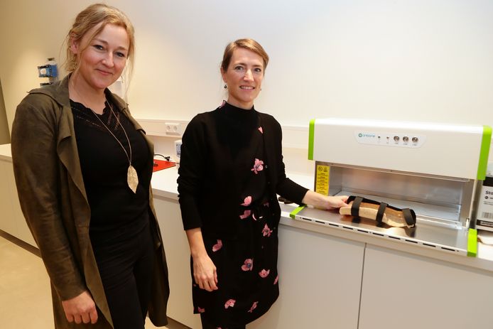 Nicoline de Haas (links) en Berbel Sluijter met een houten spalk. In het apparaat wordt de spalk verwarmd waarna deze beter te vormen is.