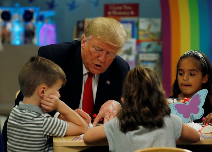 Amerikaans president Donald Trump kleurt een vlag in, samen met enkele kinderen in een kinderziekenhuis in Columbus, Ohio.