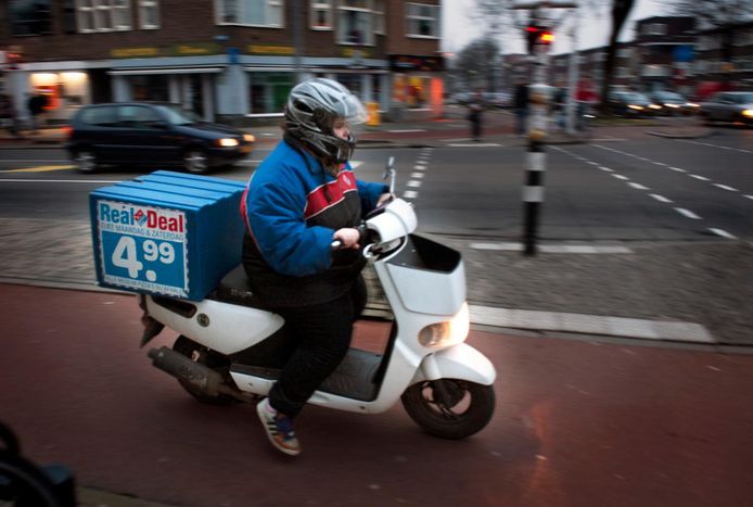 Een pizzakoerier op een elektrische scooter.