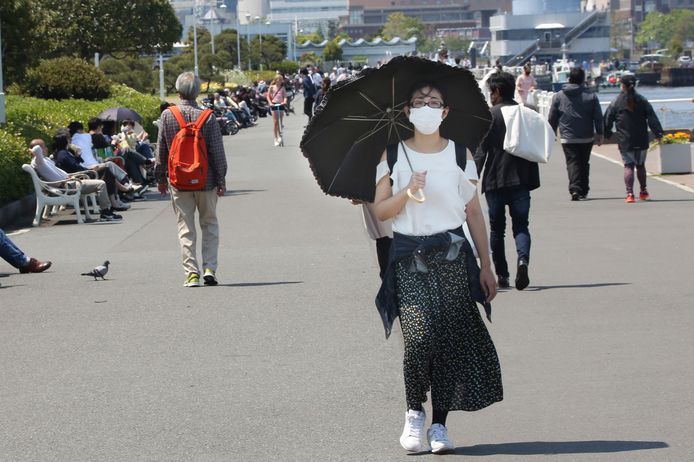 Een Japanse vrouw wandelt door een park in Yokohama, vlakbij Tokio, terwijl Japan worstelt met een tweede golf besmettingen.