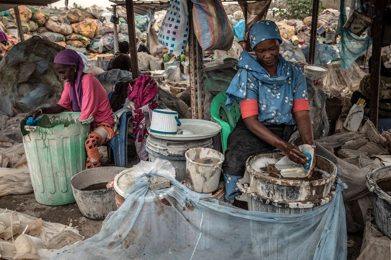 Vrouwen wassen plasticafval voor recyclage. Niks uit de afvalberg verkoopt tegenwoordig zo gemakkelijk als plastic. Beeld NYT/FINBARR O'REILLY