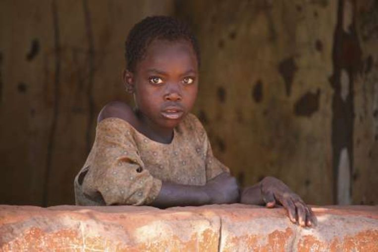 Een meisje kijkt uit haar woonst in Lilongwe, waar Madonna momenteel vertoeft. Beeld UNKNOWN