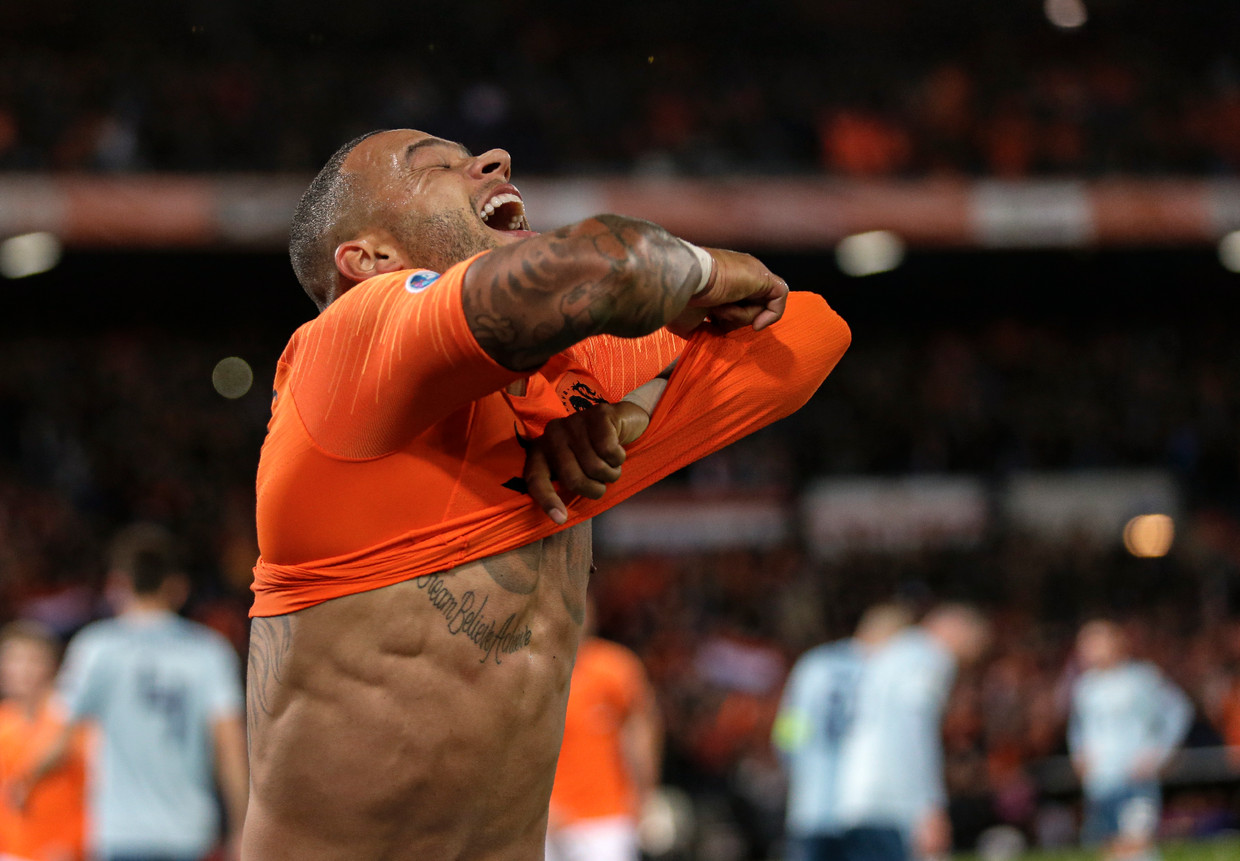 Memphis Depay trekt zijn shirt uit na het maken van een doelpunt en zal hiervoor een gele kaart krijgen. Beeld AP