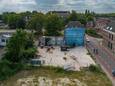 Het terrein van de voormalige Kamper Glashandel aan de Boven Havenstraat met achter blauw plastic het kraakpand.